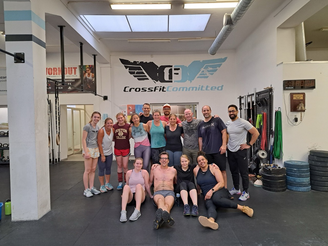 A big group of members smiling together after a class under the CrossFit Committed logo