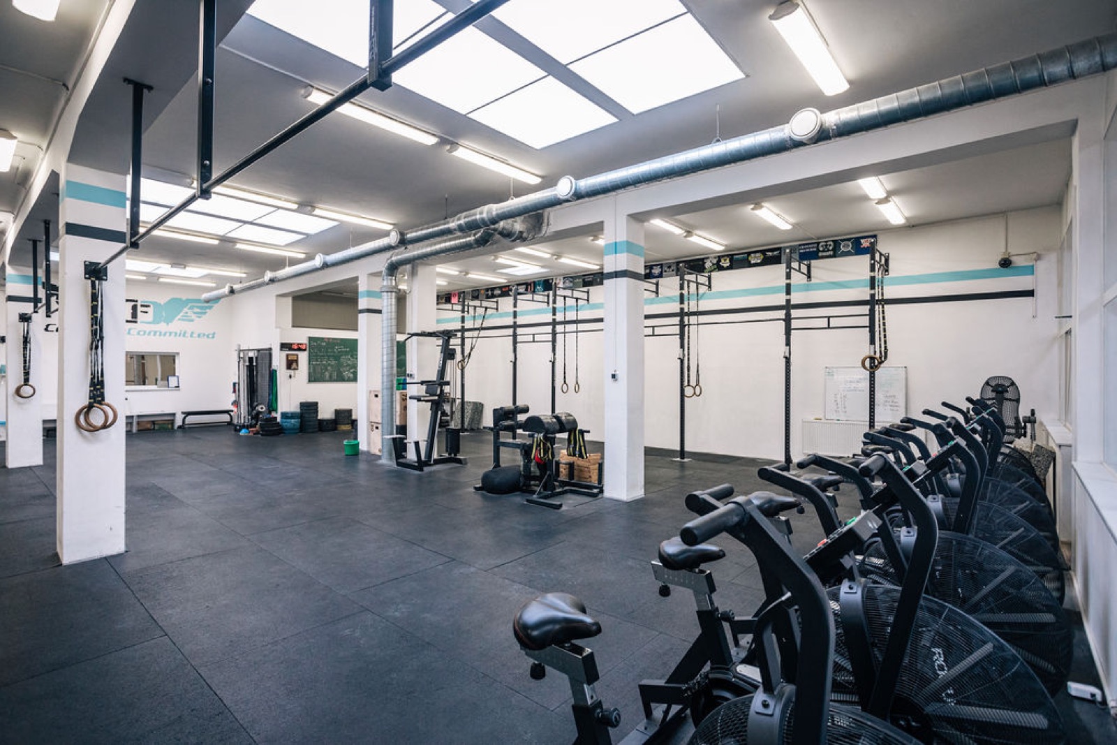 The private CrossFit Committed training floor in Žižkov: rig, rings and air bikes, no crowds